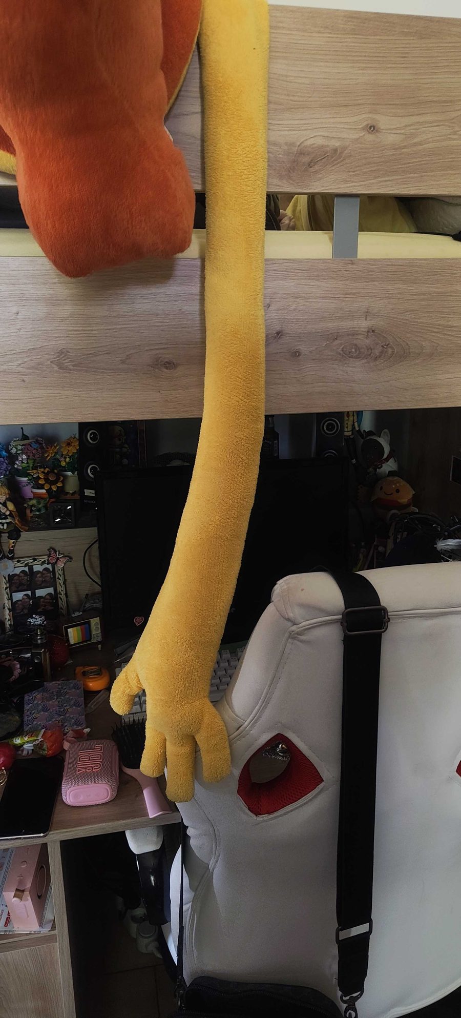 Long bras jaune de la peluche crocodile qui pend jusqu'au bureau